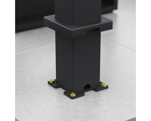 Gros plan sur un support de pavillon noir avec des vis dorées sur un fond gris.