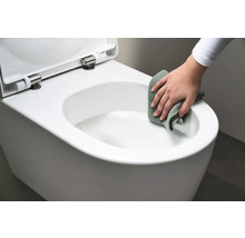 Eine Person reinigt eine weisse Hänge-Toilette mit einem Tuch.