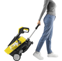 Frau zieht gelben und schwarzen Hochdruckreiniger