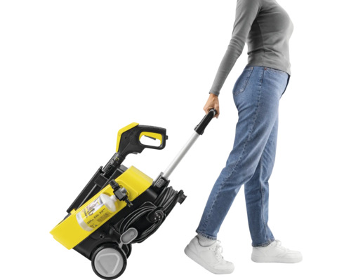 Frau zieht gelben und schwarzen Hochdruckreiniger