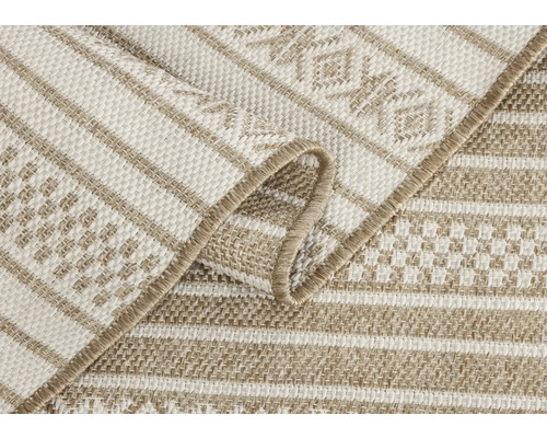 Vue détaillée d'un tapis d'extérieur beige avec un motif rayé