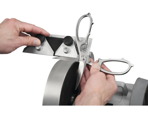 Schleifmaschine im Einsatz zum Schärfen einer Schere.