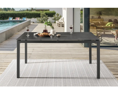 Table à manger en aluminium et céramique sur une terrasse avec piscine