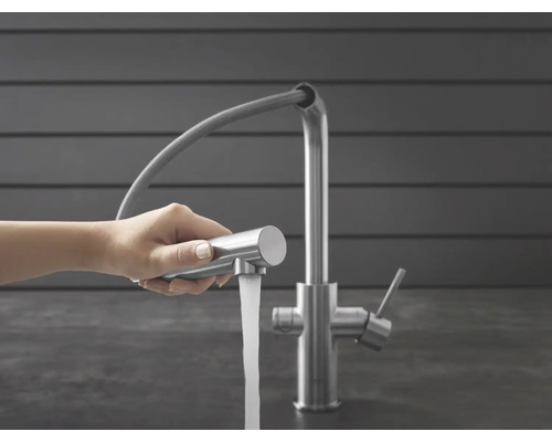 Robinet de cuisine avec douchette extractible et jet d'eau dans la main