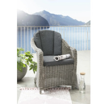 Geflochtener Sessel mit Kissen und Zeitungsrolle auf einem Balkon mit Seeblick