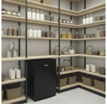 Organisierte Vorratskammer mit schwarzen Metallregalen, hellen Holzbrettern, integrierter LED Beleuchtung, Vorratsgläsern und kleinem Kühlschrank.