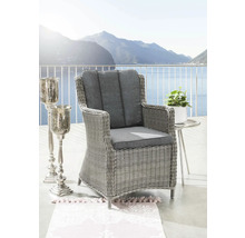 Gartenstuhl mit grauen Polstern, Beistelltisch und Kerzenständer auf einer Terrasse mit Seeblick