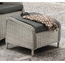 Geflochtener Outdoor-Hocker mit Polsterauflage, Schal und Sonnenbrille