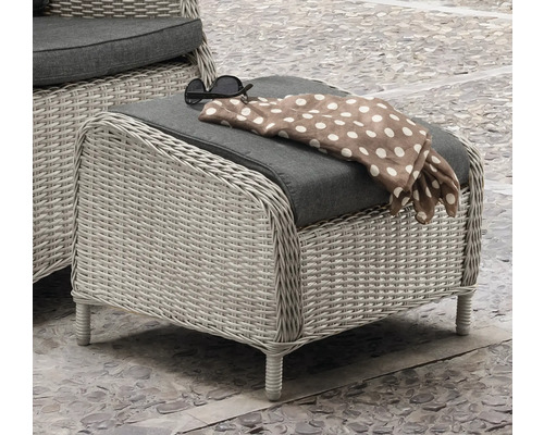 Geflochtener Outdoor-Hocker mit Polsterauflage, Schal und Sonnenbrille