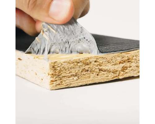 Gros plan d'une main retirant un film protecteur d'une plaque de bois revêtue