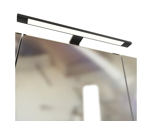 Schwarze LED-Spiegelleuchte zur Aufsatzmontage auf einem Badezimmerspiegel, geradliniges Design.