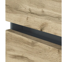 Vue détaillée d'un meuble de salle de bain avec façades aspect bois et une poignée encastrée gris foncé.