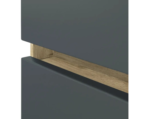 Détail d'un meuble gris avec une poignée encastrée horizontale en bois clair.