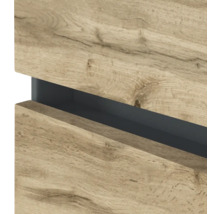 Vue détaillée d'une façade de meuble sans poignée en aspect chêne avec une poignée encastrée sombre.