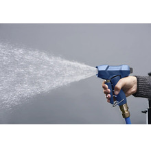 Une main tient un pistolet de pulvérisation bleu d'où jaillit de l'eau.