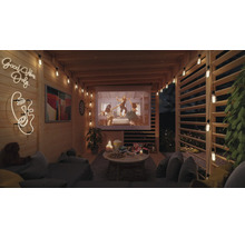 Espace extérieur confortable avec écran de projection, guirlandes lumineuses et sièges pour une soirée cinéma détendue