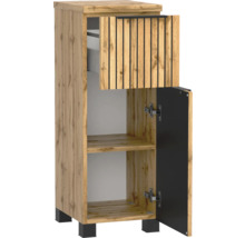 Meuble de salle de bain étroit aspect chêne avec façade à lattes sur le tiroir, une porte ouverte, pieds noirs et poignée noire.