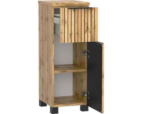 Meuble de salle de bain étroit aspect chêne avec façade à lattes sur le tiroir, une porte ouverte, pieds noirs et poignée noire.
