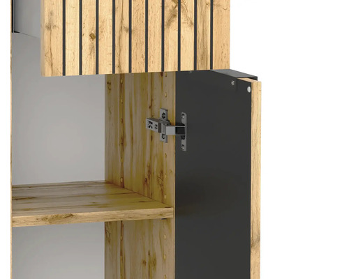 Gros plan d'un meuble de salle de bains aspect chêne avec des lattes noires sur la façade et une charnière métallique sur la porte ouverte.