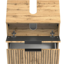 Meuble sous-vasque aspect bois avec lamelles verticales noires, tiroir supérieur ouvert et découpe pour siphon.