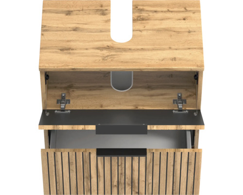 Meuble sous-vasque aspect bois avec lamelles verticales noires, tiroir supérieur ouvert et découpe pour siphon.