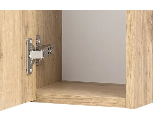 Nahaufnahme eines silberfarbenen Möbelscharniers an einem Schrank in Eichenoptik mit geöffneter Tür.