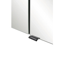 Nahaufnahme einer Spiegeltür eines Badezimmerschranks mit einem schwarzen Metallgriff an der Unterkante.