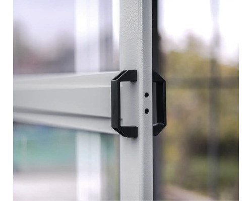 Nahaufnahme eines schwarzen Türgriffs an einem Metallrahmen.