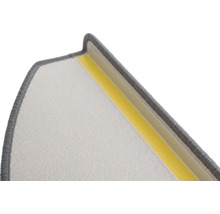 Détail d'une marche d'escalier avec surface textile et bande adhésive pour la fixation.