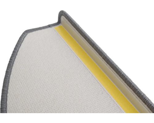 Détail d'une marche d'escalier avec surface textile et bande adhésive pour la fixation.