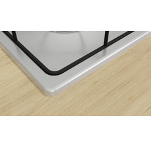 Detailansicht eines Kochfelds aus Edelstahl auf einer Holzarbeitsplatte