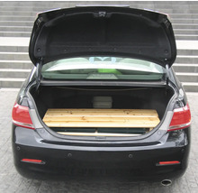 Coffre ouvert d'une voiture avec une palette en bois