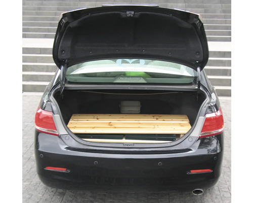 Coffre ouvert d'une voiture avec une palette en bois
