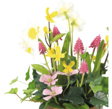 Dekorative Kunstblumen-Arrangement mit verschiedenen Blumenarten und grünen Blättern.