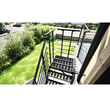 Außenansicht einer Metalltreppe mit Geländer in einem Garten.