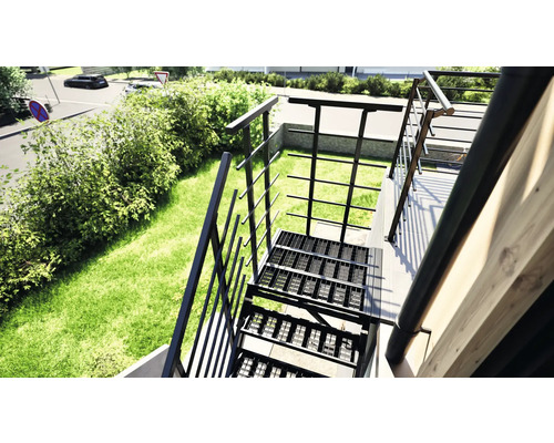 Außenansicht einer Metalltreppe mit Geländer in einem Garten.