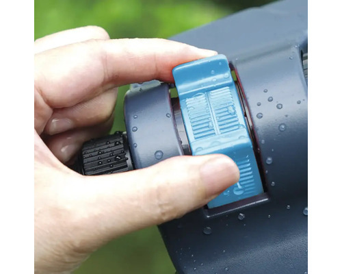 Main actionnant l'arroseur pour l'irrigation du jardin