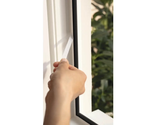 Application de ruban d'étanchéité pour fenêtre sur le cadre de la fenêtre