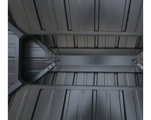 Vue intérieure d'un abri de jardin métallique avec construction de toit et crochets de rangement