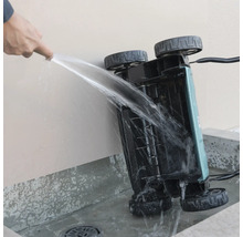 Nettoyage du dessous d'un scarificateur avec un jet d'eau.