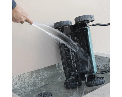Nettoyage du dessous d'un scarificateur avec un jet d'eau.