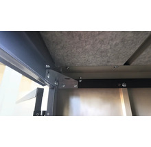 Gros plan de la construction métallique et du dessous d'un produit, fixé par des vis.