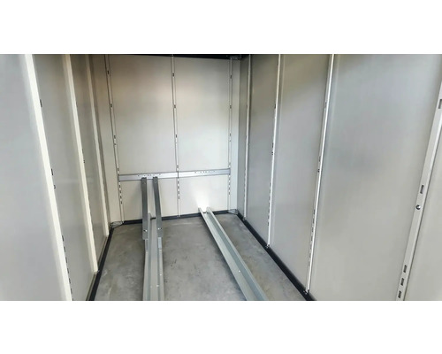 Vue intérieure d'une armoire de stockage avec des éléments métalliques pour le montage des étagères.