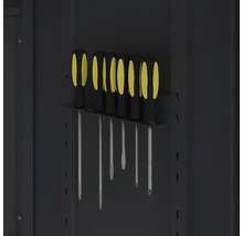 Jeu de tournevis avec manches noirs et jaunes dans un support métallique sur une paroi d'outillage.