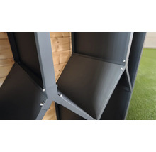 Vue détaillée d'un raccord d'angle en métal gris pour un abri de jardin avec des vis apparentes devant une paroi en bois.