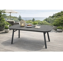 Table de jardin rectangulaire moderne aux coins arrondis sur une terrasse lumineuse et spacieuse. Table gris foncé avec cadre en métal.