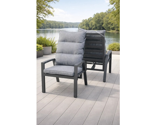 Zwei moderne graue Gartenstühle mit Metallgestell und gepolsterten Auflagen auf einer Holzterrasse an einem See.