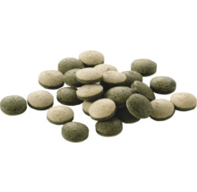 Pastilles de nourriture vertes et beiges pour poissons, de forme ronde.