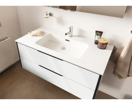 Weißer Waschtischunterschrank mit zwei Schubladen und integriertem Waschbecken sowie verchromter Armatur in einem hellen Badezimmer.