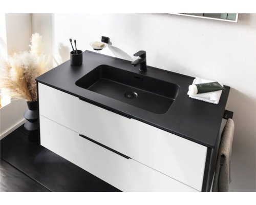 Moderner Waschtischunterschrank mit zwei weißen Schubladen, schwarzer Waschtischplatte mit integriertem Becken und schwarzer Armatur.